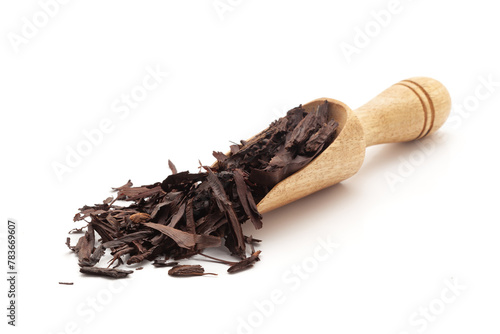 Front view of a wooden scoop filled with Organic Alkanet or Ratan Jot (Alkanna tinctoria) roots. Isolated on a white background. photo