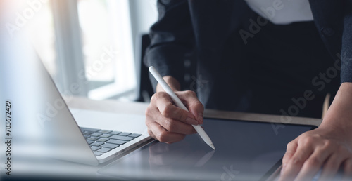 Businesswoman using stylus pen signing on digital tablet via mobile app, proofing e-document on office table. Business woman, project manager planning and working on computer, business technology