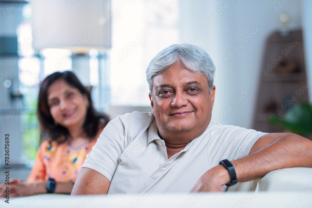 Indian asian senior couple spends quality time sitting on sofa in living room . Indian asian senior couple spends quality time sitting on sofa in living room .