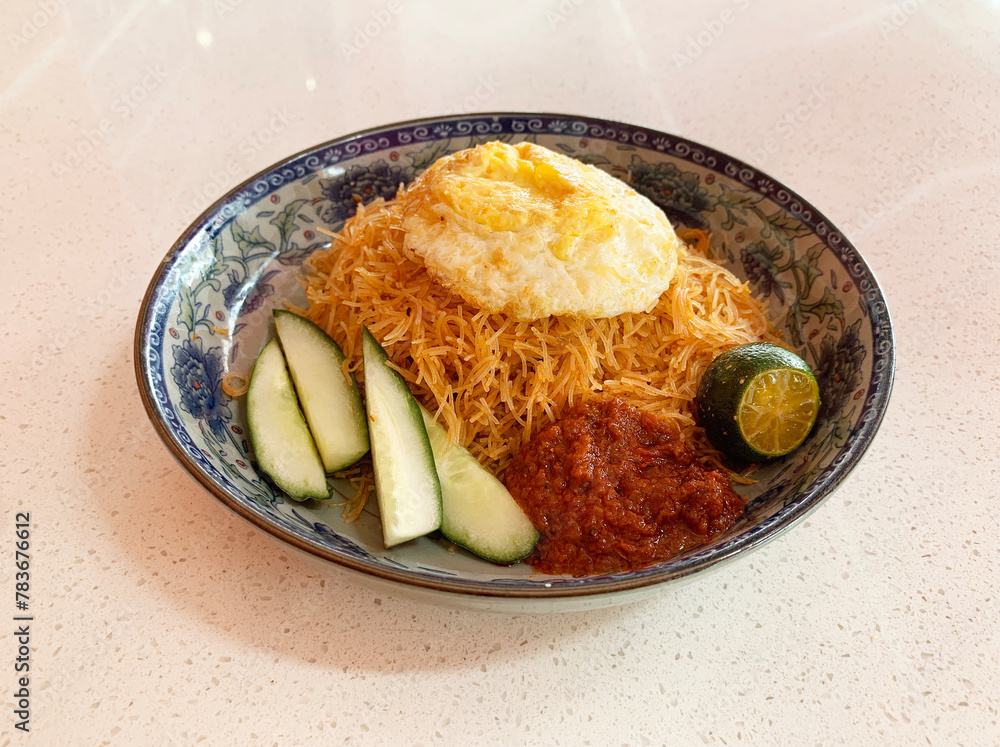 traditional peranakan wok stir fried nonya mee siam noodle spicy chilli shrimp goreng with egg lime sambal cucumber in plate on vintage table asian cafe hotel luxury halal food restaurant banquet menu