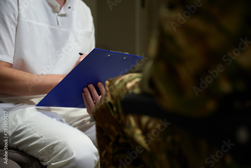 Healthcare professional writing down medical history of military man