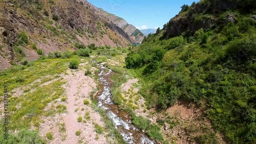 First-person view of river filling the jade Urungach lake in Uzbekistan photo