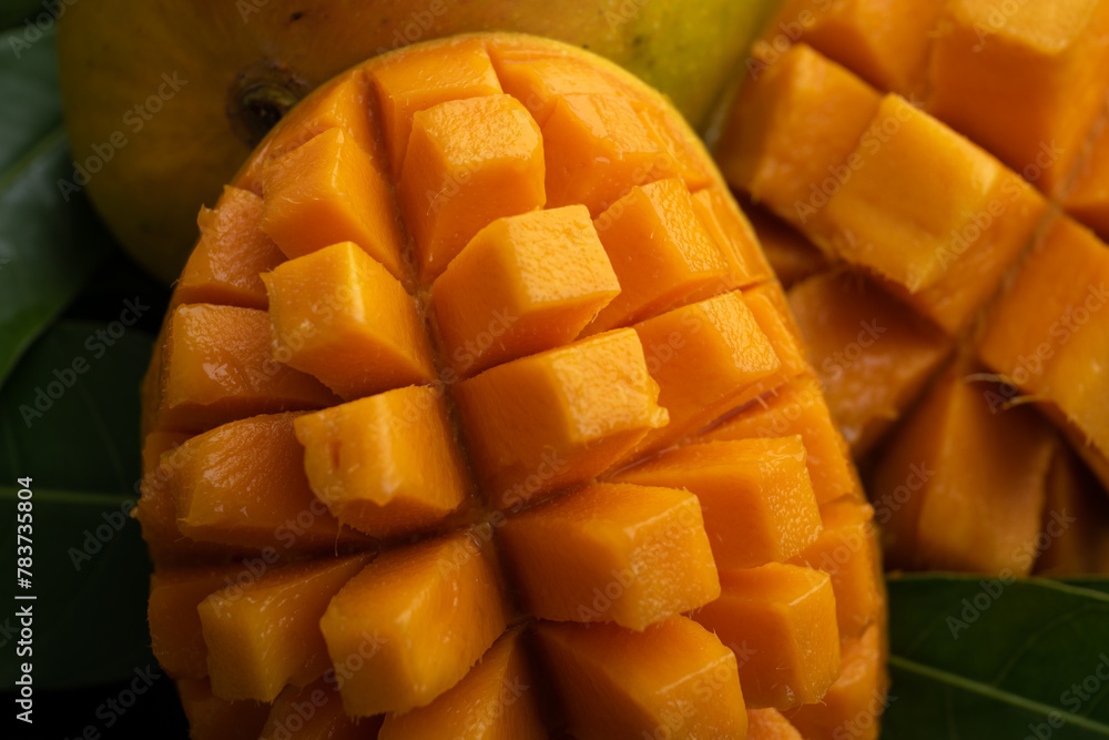Mango tropical fruit with slice and half cut on green leaf background Mango tropical fruit with slice and half cut on green leaf background