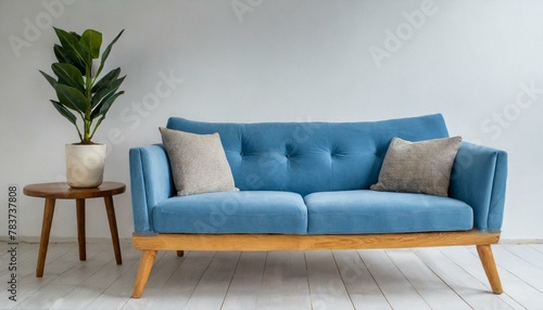 A staple food in the world of comfort, a blue couch with wooden legs on a white background