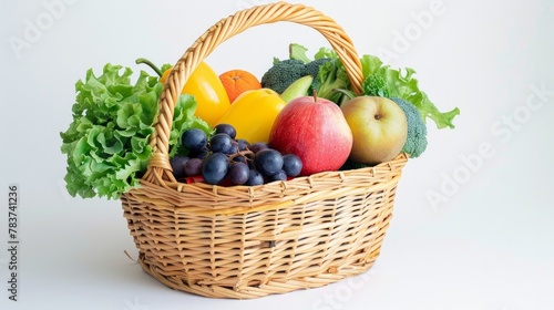 Fresh fruits and vegetables in a wicker basket on a white background.