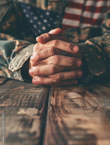 A close-up view of a soldier's hands, worn from service, clasped together in a pose of reverence and remembrance - a poignant representation of the sacrifices made for one's country.