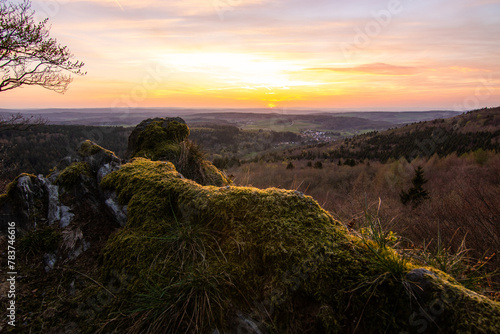 Panorama of a Romanesque landscape at sunset in the evening light. beautiful spring landscape in the mountains. Grass field and rolling hills. View from a rock to the horizon