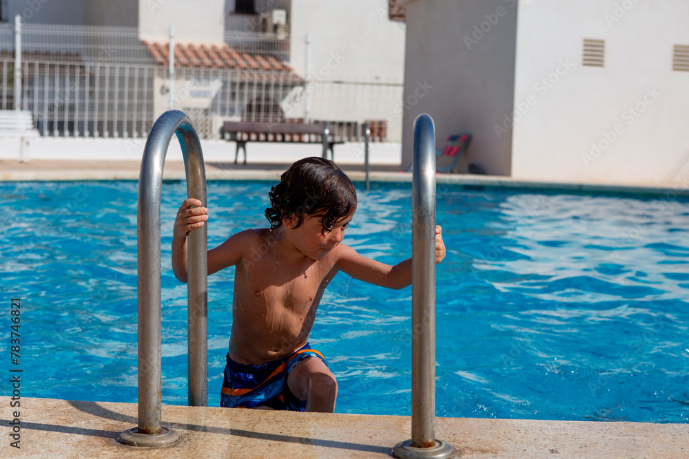 Boy Exiting Swimming Pool Grabbing Ladder