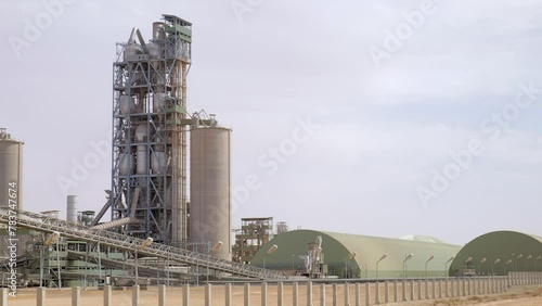 Cement plant with high factory structure and tower crane at industrial production area photo