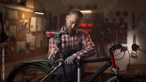 Bike mechanic man repairs bicycle in repair workshop. Diagnostics and repairs of the bicycle. Bike maintenance concept. photo