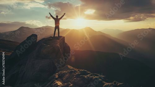 Hiker hiking man open arms stands on top of mountain with clouds sky during sunset photo