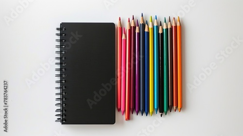 Top View Spiral Notebook and Colorful Pencils Arrangement for Mockup photo