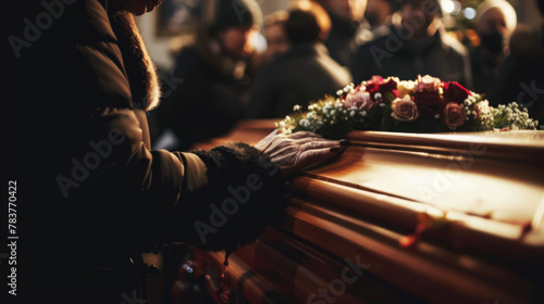Hand touching a coffin, last respect