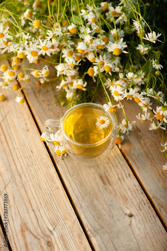 Herbal tea based on chamomile on a wooden table. Vertical frame