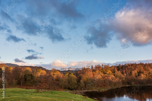 Beautiful Spring landscape image in Lake District looking towards Langdale Pikes during colorful sunset