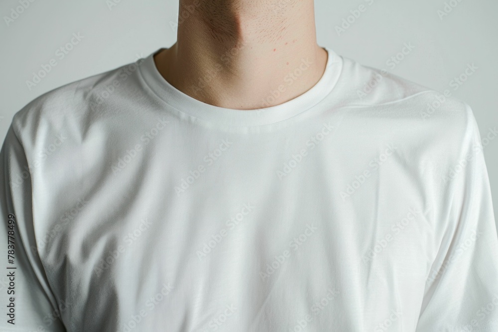 Young man in white tshirt standing against gray background, confident and casual look Young man in white tshirt standing against gray background, confident and casual look