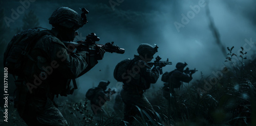 Soldiers on a night patrol maneuver through terrain, alert and ready with rifles in hand amidst the darkness