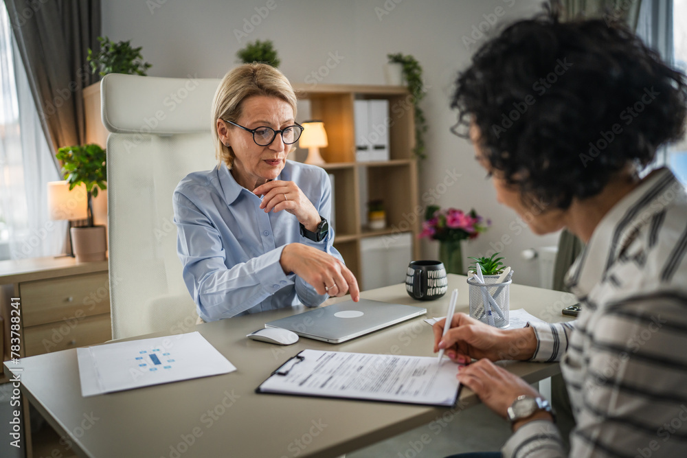 Two mature woman signature document, contract at work at office