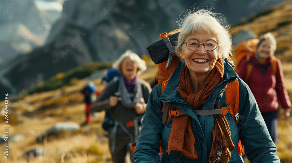 group of active senior citizens outside hiking in mountain with backpack smiling and looking at camera group of active senior citizens outside hiking in mountain with backpack smiling and looking at camera
