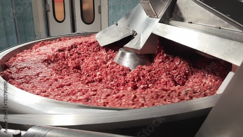 Processing of production minced meat in industrial meat grinder, close up. Modern technologies in Food industry