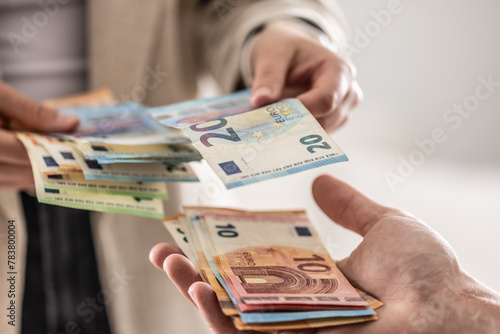 Businesswoman's hands exchanging euro banknotes, closeup shot photo