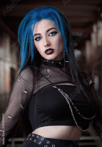 Close-up indoor portrait of beautiful goth (deathrock) girl dressed in black leaky blouse . Dark beauty