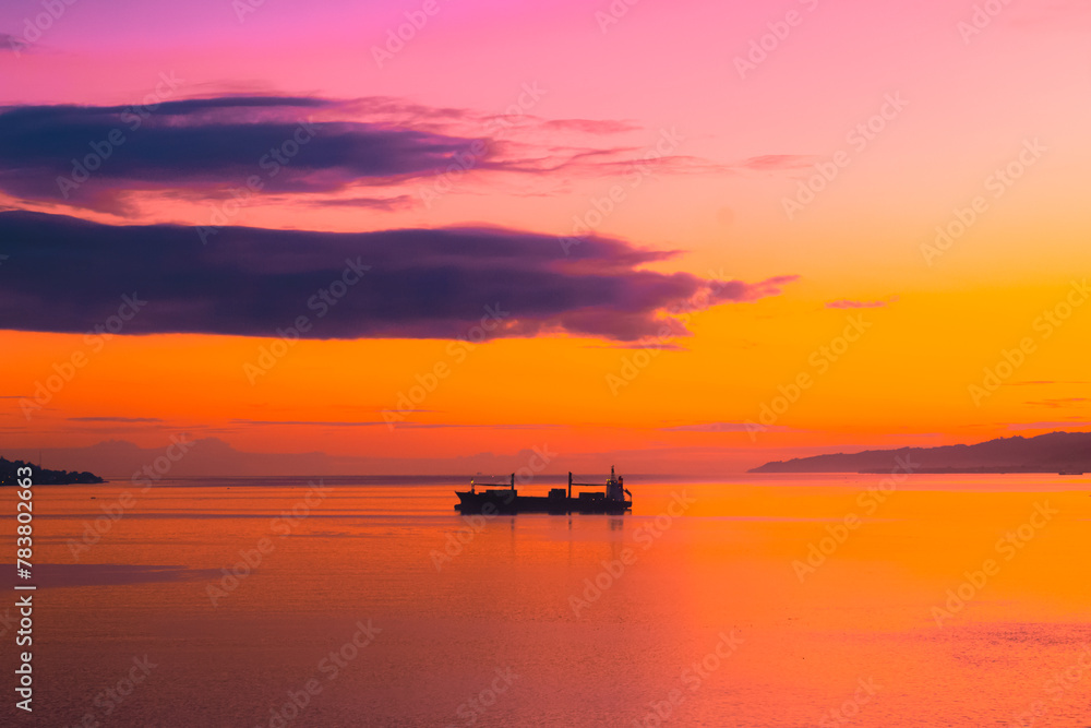Naklejka premium Sunset and ship silhouettes in Ambon Bay, Indonesia