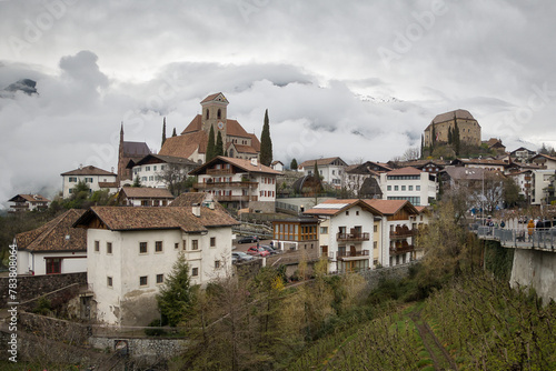 Panoramablick über eine Dorfgemeinde in Südtirol an einem stark bewölkten Tag