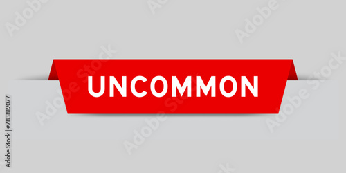 Red color inserted label with word uncommon on gray background