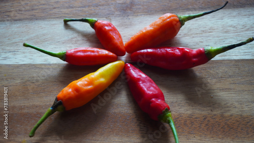 Isolated flat lay cayenne pepper or Capsicum annuum also commonly called Birds Eye on a wooden tray. Selective focus                             photo
