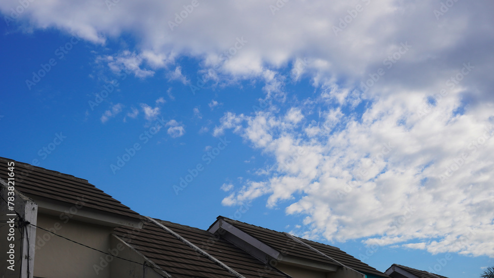 House roof tiles or roof top of residential house with Blue sky and dense white clouds on a sunny day for background and template. Selective focus                                                  