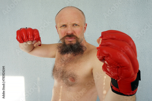 Boxer in red boxing gloves. Athlete, bodybuilder, athlete, muscle, sport, mma, fight, danger.                            Pugilist, mauler, pug, sparrer, prize-fighter
