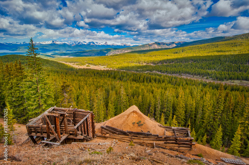 The image captures the essence of Colorado's heartland featuring the stunning nature, mountains, and remnants of an old structure as a testament to times past
