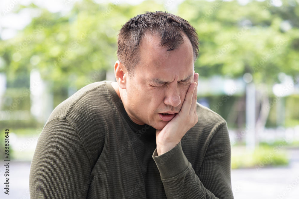 Middle aged Asian Man suffering from Toothache, Tooth decay, Tooth pain, gingivitis, Seeking Dental Pain Relief and Oral Health Care Middle aged Asian Man suffering from Toothache, Tooth decay, Tooth pain, gingivitis, Seeking Dental Pain Relief and Oral Health Care