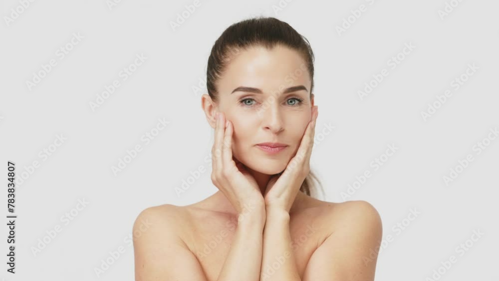 Gorgeous middle aged woman touching her perfect skin. Beautiful portrait of a 40-50 year old woman advertising anti-aging facial products, salon care, skin tightening, isolated on white background. Gorgeous middle aged woman touching her perfect skin. Beautiful portrait of a 40-50 year old woman advertising anti-aging facial products, salon care, skin tightening, isolated on white background.