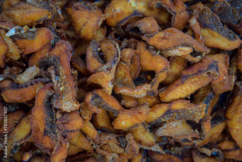 A pile of fried fish with a lot of seasoning. The fish are cut into small pieces and are fried in oil