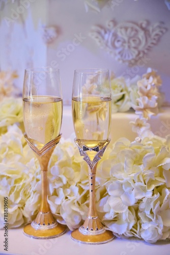 Festive drinks glasses for the newlyweds on the background of the wedding cake. The wedding table.