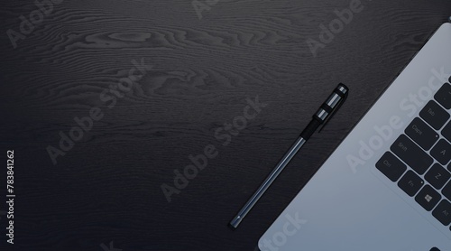 Copy space of pen and laptop on a black wooden desk
