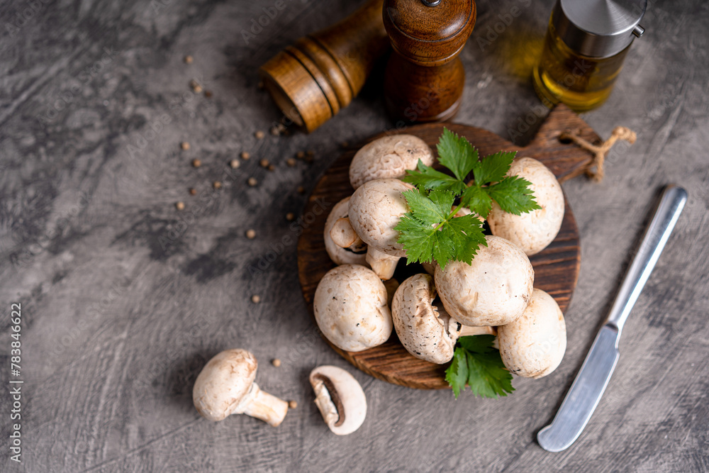 Raw white mushrooms champignons and pepper on grey background for cooking fresh ingredients. free copy space Raw white mushrooms champignons and pepper on grey background for cooking fresh ingredients. free copy space