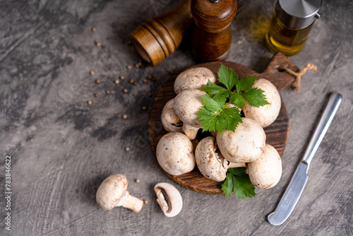 Raw white mushrooms champignons and pepper on grey background for cooking fresh ingredients. free copy space