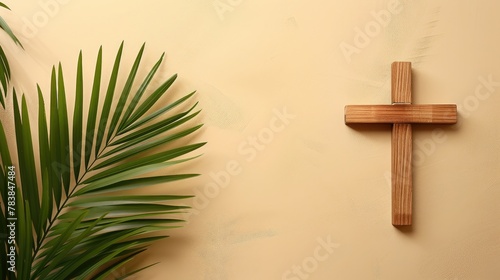 Palm, wooden cross and palm leaves on neutral background with copy space for text. Christianity, faith, religion.