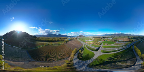 360 Aerial View of the Farms and Mountains. Dramatic Sunny Sunset Sky.