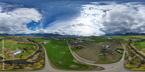 360 Aerial View of the Farms and Mountains. Dramatic Cloudy Sky.