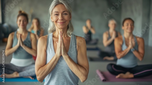 Happy smiling older women practice yoga in group classes in the fitness room