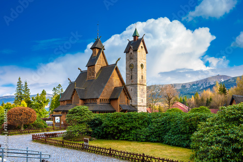 Medieval Norwegian stave wooden church Vang or Wang in summer and Snezka mountain in the background. Church was transferred from Vang in Norway to Karpacz in 1842. Karpacz, Poland photo