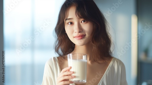 Young Asian woman holding a glass of milk 