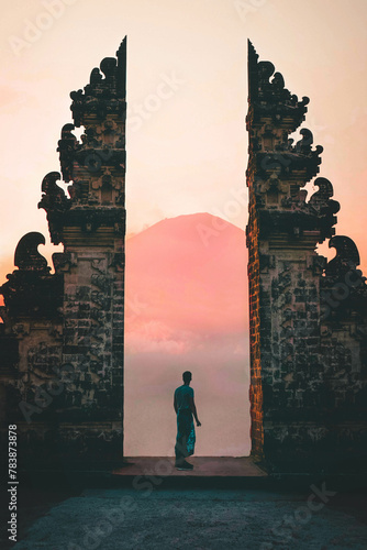 Young Man Silhouette Standing At Balinese Gate In Lempuyang Temple Watching Mount Agunt At The Sunset, Bali, Indonesia photo