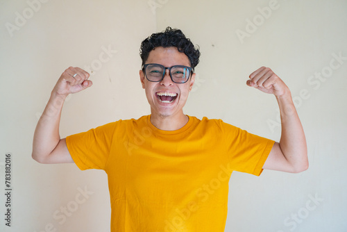 Young man wear yellow t-shirt with strong pose expression gesture. The photo is suitable to use for man expression advertising and fashion life style.