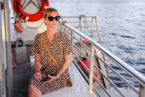 Fort Lauderdale, Florida - March 23, 2024: A fashionable woman taking in the sights froma boat along the canals of Fort Lauderdale, Florida
 photo