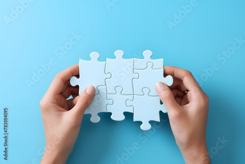 Businessman holding a jigsaw puzzle over bright background.